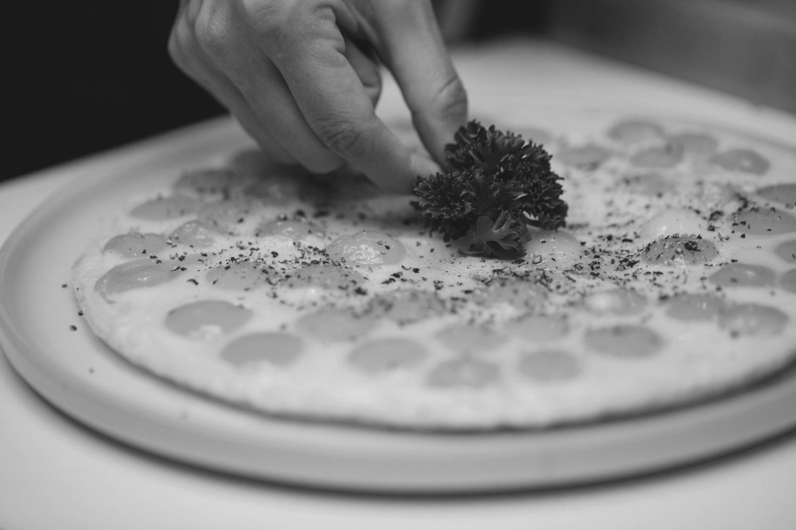Close-up of tempered chocolate shards arranged with geometric precision on a ceramic plate